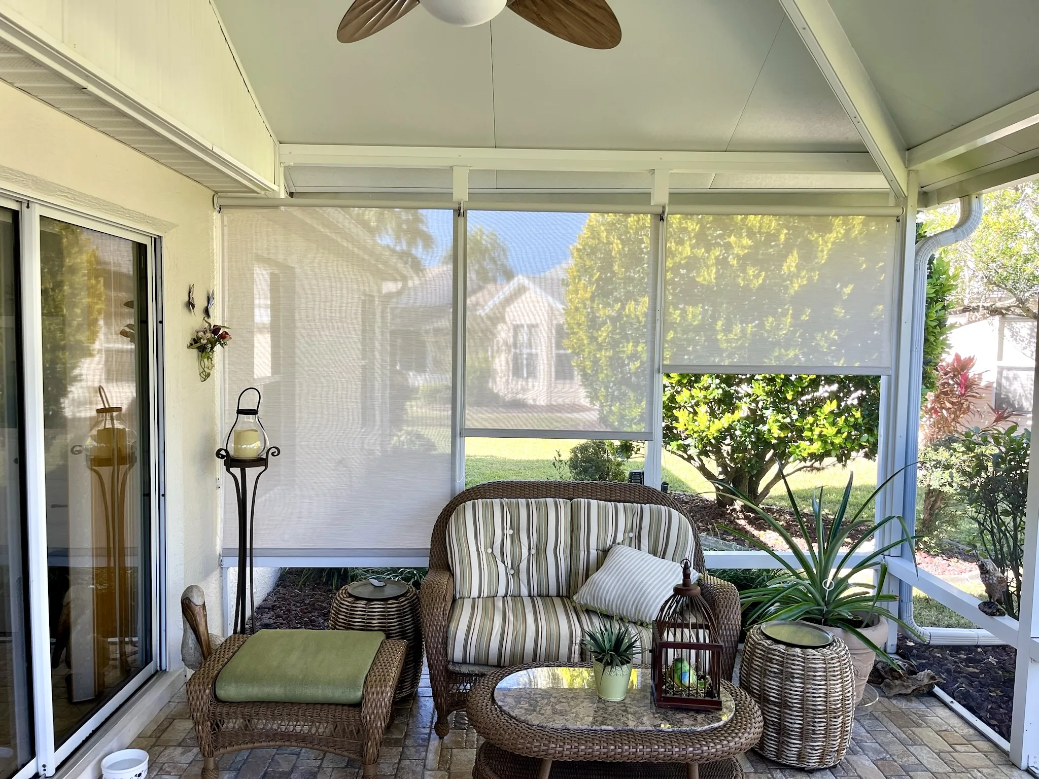 Interior glass-lanai roller solar shades with a view to the garden